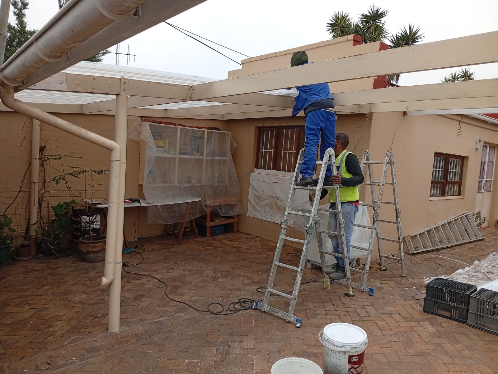 Eco Projects team renovating and painting an outdoor timber structure
